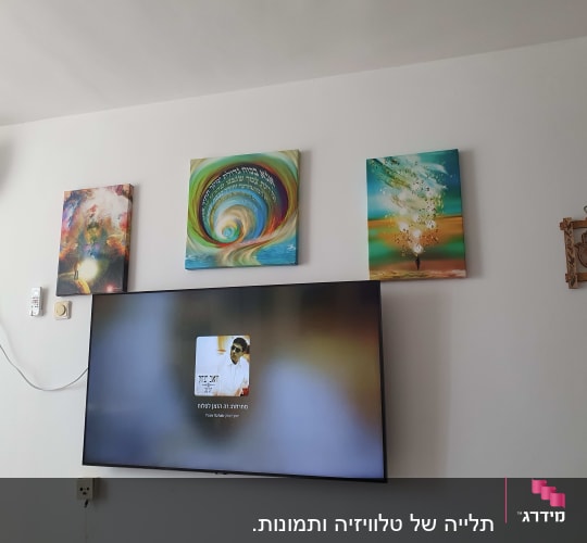 קיר עם טלוויזיה ותמונות תלויות